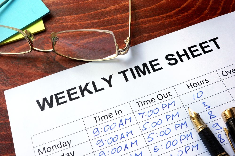 Piece of paper on a table titled "weekly time sheet"